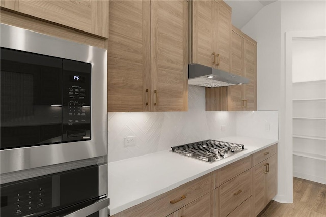 13504 Thomas Wheeler Way, Manor, TX 78653 - kitchen with built in microwave, under cabinet range hood, oven, stainless steel gas stovetop, and tasteful backsplash