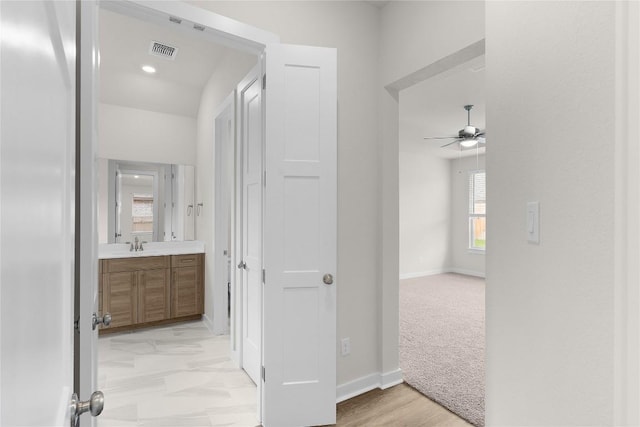 13504 Thomas Wheeler Way, Manor, TX 78653 - corridor with baseboards, a sink, and light carpet