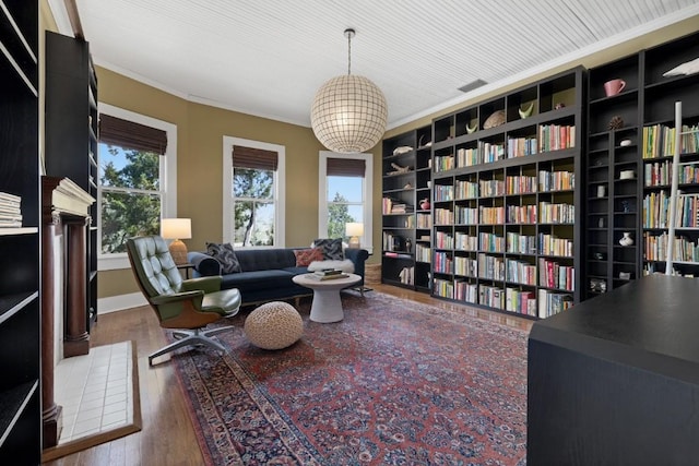 2124 Bluebonnet Ln, Austin, TX 78704 - living area featuring wood finished floors, crown molding, built in features, and wall of books