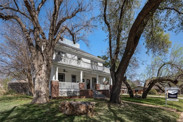 2124 Bluebonnet Ln, Austin, TX 78704 - traditional style home featuring a balcony, a ceiling fan, covered porch, and a front lawn