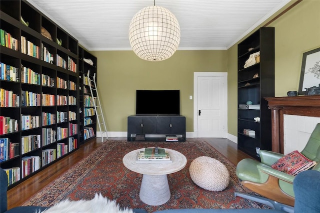 2124 Bluebonnet Ln, Austin, TX 78704 - living room with built in shelves, crown molding, wall of books, wood finished floors, and a chandelier