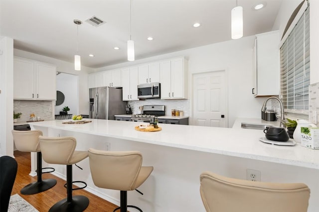 2126 Simbrah Dr, Cedar Park, TX 78613 - kitchen featuring appliances with stainless steel finishes, a sink, a peninsula, decorative backsplash, and light countertops