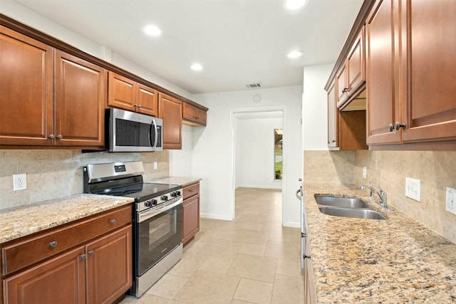 1304 Knollwood Cv, Round Rock, TX 78681 - kitchen with stainless steel appliances, a sink, tasteful backsplash, baseboards, and light stone counters