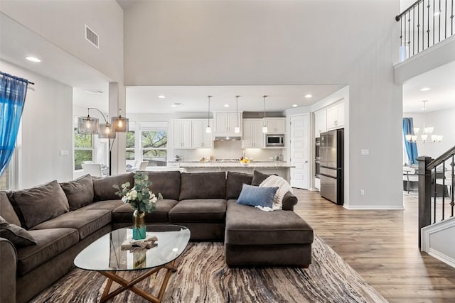5621 Cypress Ranch Blvd, Spicewood, TX 78669 - living room featuring a high ceiling, light wood-style floors, stairs, a chandelier, and recessed lighting