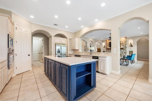 4321 Lakeway Blvd, Austin, TX 78734 - kitchen with stainless steel appliances, light tile patterned floors, light countertops, a center island, and blue cabinetry