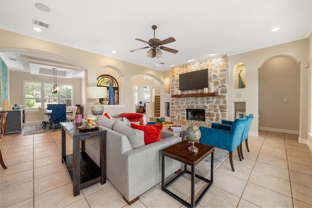 4321 Lakeway Blvd, Austin, TX 78734 - living room with light tile patterned floors, a stone fireplace, a ceiling fan, arched walkways, and recessed lighting