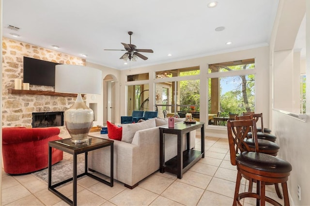 4321 Lakeway Blvd, Austin, TX 78734 - living area featuring light tile patterned floors, a ceiling fan, arched walkways, ornamental molding, and a fireplace