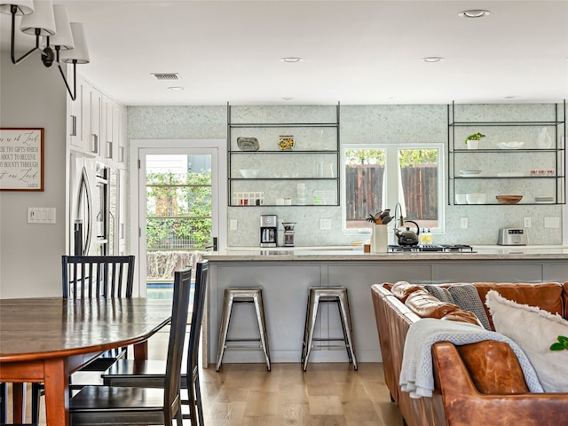 1004 Maufrais St, Austin, TX 78703 - kitchen with white cabinetry, light wood finished floors, decorative backsplash, and light countertops
