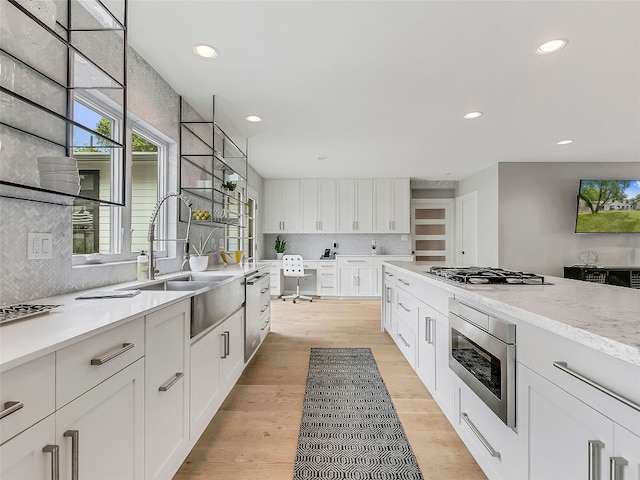 1004 Maufrais St, Austin, TX 78703 - kitchen featuring appliances with stainless steel finishes, recessed lighting, decorative backsplash, white cabinetry, and light wood-style floors