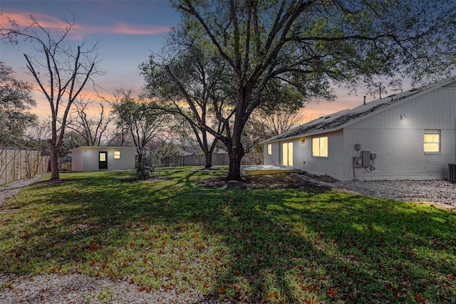 6303 Bexton Cir, Austin, TX 78745 - yard at dusk featuring a fenced backyard and an outdoor structure