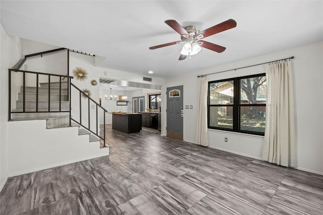 906 E Village Ln, Austin, TX 78758 - unfurnished living room with stairway, a chandelier, and a ceiling fan