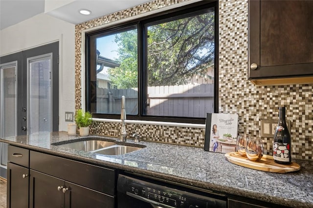 906 E Village Ln, Austin, TX 78758 - kitchen featuring black dishwasher, dark brown cabinetry, decorative backsplash, and dark stone counters