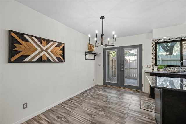 906 E Village Ln, Austin, TX 78758 - unfurnished dining area featuring a chandelier, healthy amount of natural light, and french doors