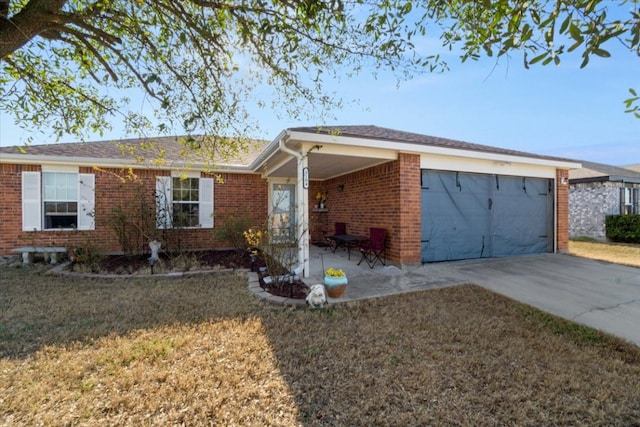 ranch-style home with driveway, a garage, a front yard, and brick siding