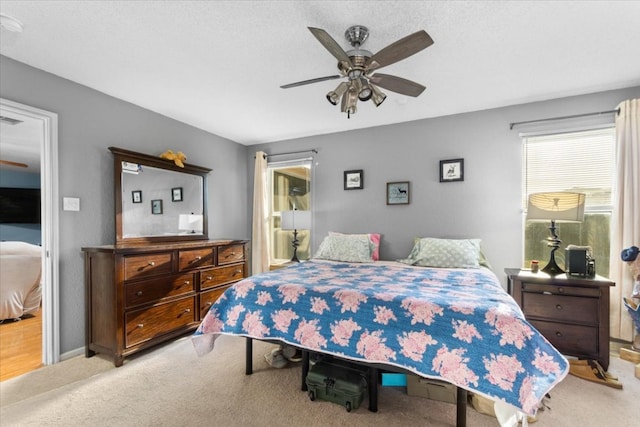 carpeted bedroom with baseboards and a ceiling fan