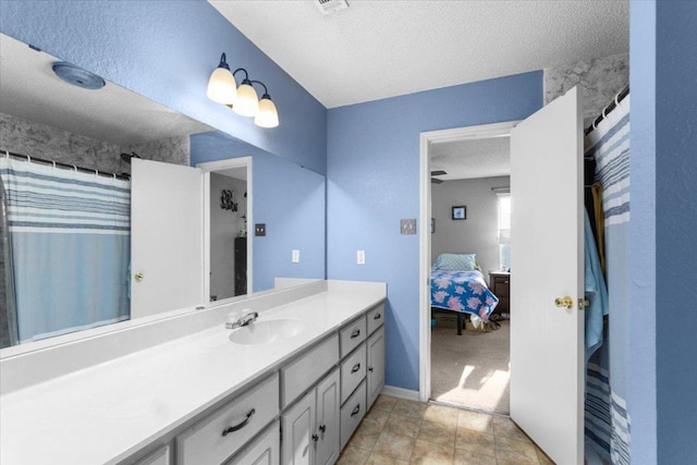 ensuite bathroom featuring ensuite bathroom, baseboards, vanity, and a textured ceiling