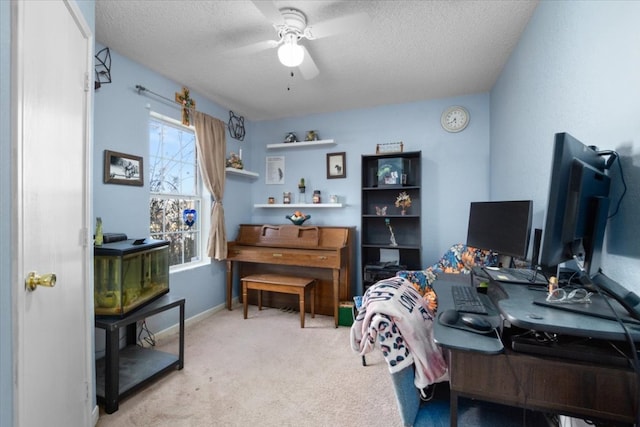 carpeted office space with a textured ceiling, ceiling fan, and baseboards