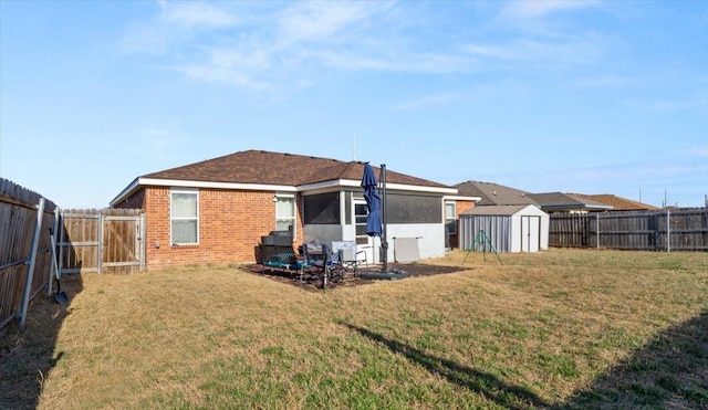 back of property with a storage shed, a yard, a fenced backyard, and an outdoor structure