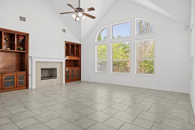15408 Prestancia Dr, Austin, TX 78717 - unfurnished living room featuring a ceiling fan, built in features, a tiled fireplace, high vaulted ceiling, and plenty of natural light