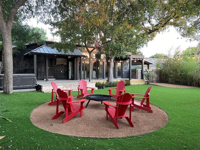 2610 Jefferson St, Austin, TX 78703 - rear view of house featuring a fire pit, a hot tub, stone siding, and a patio area