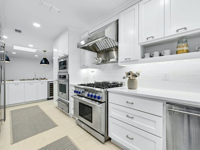 2610 Jefferson St, Austin, TX 78703 - kitchen featuring appliances with stainless steel finishes, exhaust hood, a warming drawer, light countertops, and wine cooler