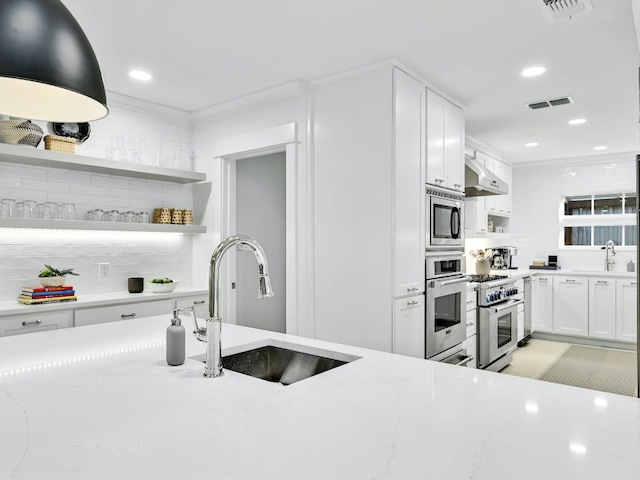 2610 Jefferson St, Austin, TX 78703 - kitchen with stainless steel appliances, open shelves, white cabinets, light stone countertops, and tasteful backsplash