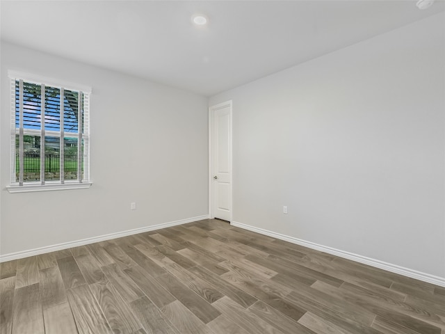 unfurnished room with baseboards and wood finished floors