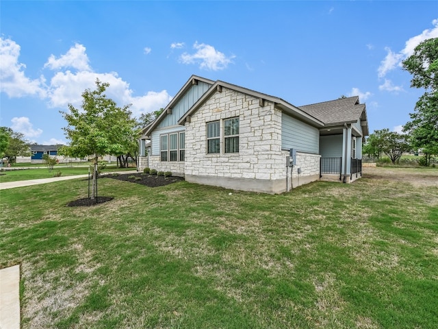 view of home's exterior featuring board and batten siding, a lawn, and stone siding