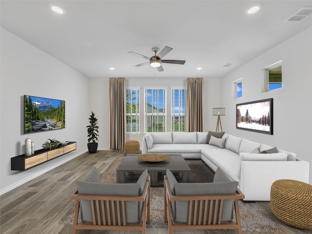 living area with a ceiling fan, wood finished floors, visible vents, and recessed lighting