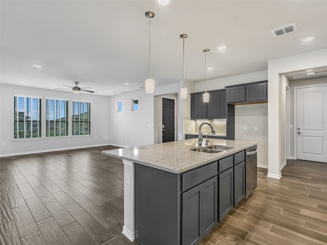 kitchen featuring dark wood-style floors, visible vents, stainless steel dishwasher, a sink, and baseboards