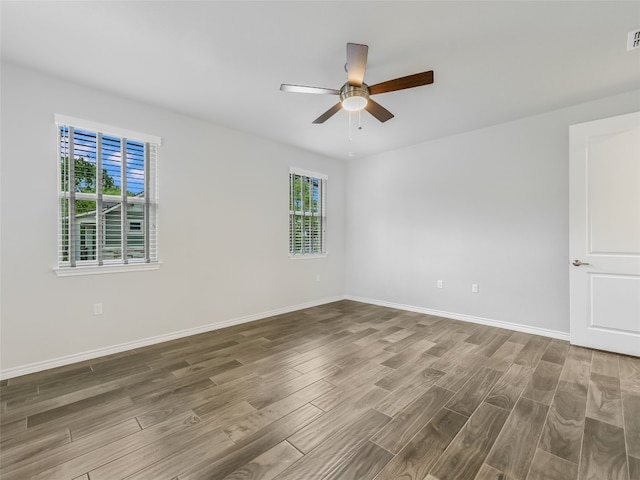 unfurnished room with visible vents, baseboards, wood finished floors, and ceiling fan