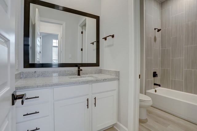 full bath with toilet, wood finished floors, vanity, and shower / tub combination
