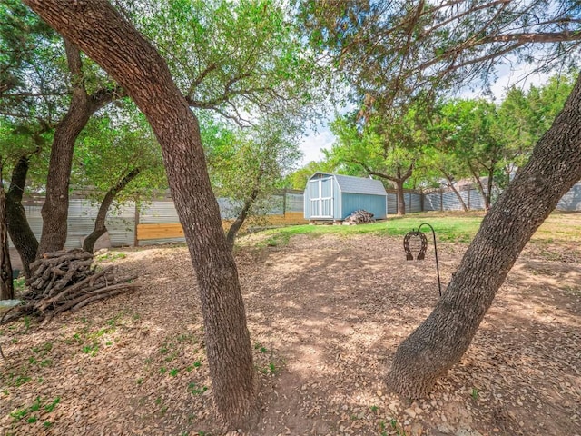 view of yard featuring fence, an outbuilding, and a storage unit