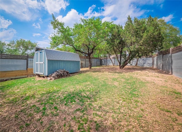 view of yard featuring a shed, a fenced backyard, and an outdoor structure