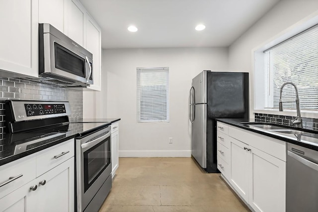512 Bouldin Ave, Austin, TX 78704 - kitchen with appliances with stainless steel finishes, plenty of natural light, decorative backsplash, white cabinetry, and recessed lighting