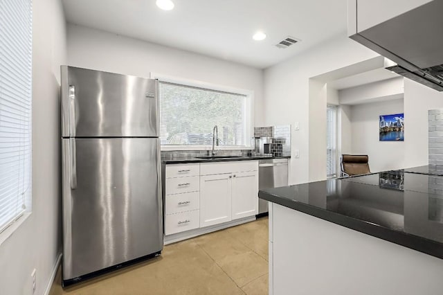 512 Bouldin Ave, Austin, TX 78704 - kitchen featuring appliances with stainless steel finishes, dark countertops, white cabinets, backsplash, and recessed lighting