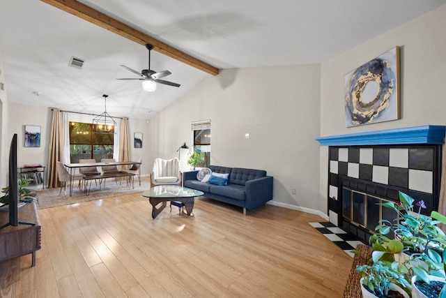 living area with light wood-type flooring, a ceiling fan, a fireplace, and baseboards