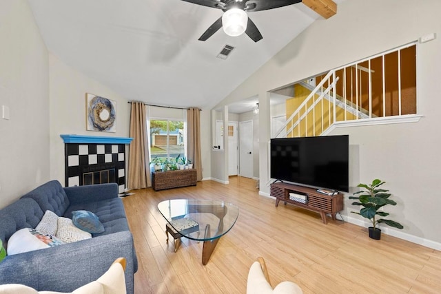 living room with vaulted ceiling, stairs, wood finished floors, ceiling fan, and baseboards