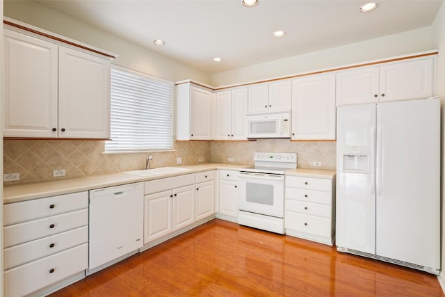 311 Dove Hollow Trl, Georgetown, TX 78633 - kitchen featuring white appliances, a sink, light countertops, light wood finished floors, and recessed lighting