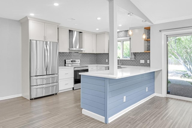3412 Eldorado Trl, Austin, TX 78739 - kitchen with appliances with stainless steel finishes, wall chimney range hood, a peninsula, light wood-style flooring, and recessed lighting