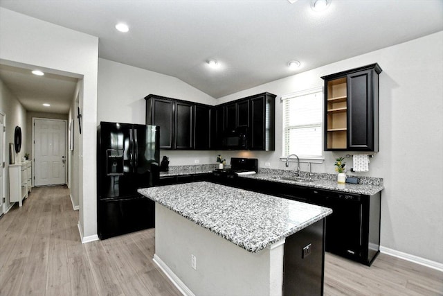5741 Porano Cir, Round Rock, TX 78665 - kitchen with black appliances, a center island, light wood-style flooring, light stone countertops, and dark cabinets