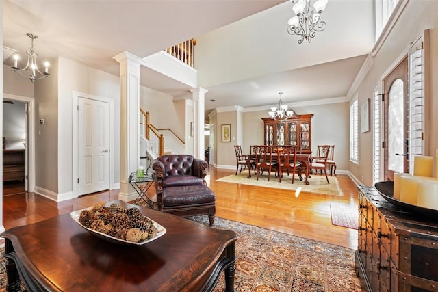 6425 Yaupon Dr, Austin, TX 78759 - living room with a chandelier, ornate columns, wood finished floors, crown molding, and stairway