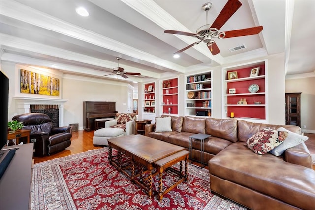 6425 Yaupon Dr, Austin, TX 78759 - living area with ceiling fan, crown molding, wood finished floors, a fireplace, and beam ceiling