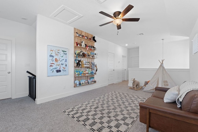 sitting room featuring attic access, carpet, baseboards, and ceiling fan