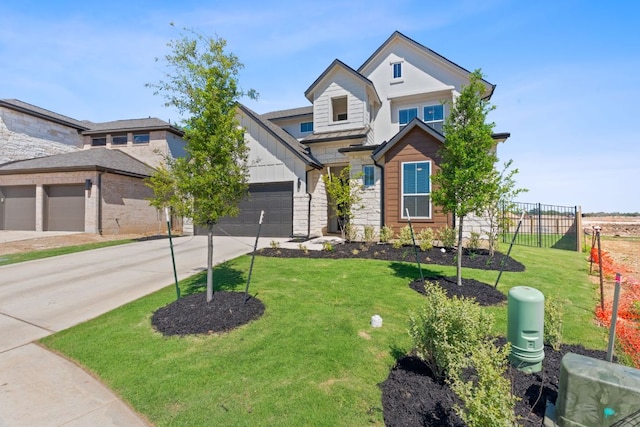 view of front of property featuring a front lawn, driveway, stone siding, fence, and an attached garage