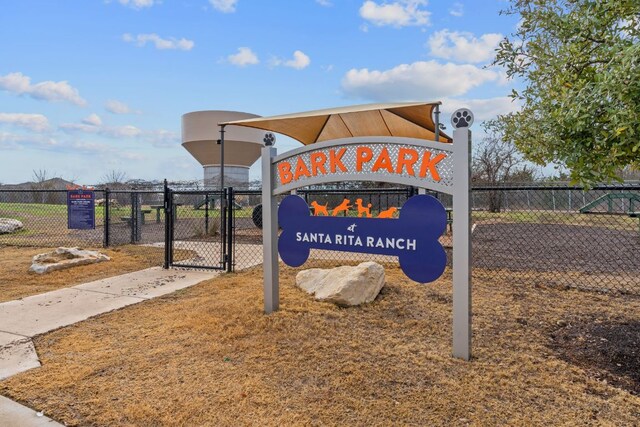 community / neighborhood sign with a gate and fence