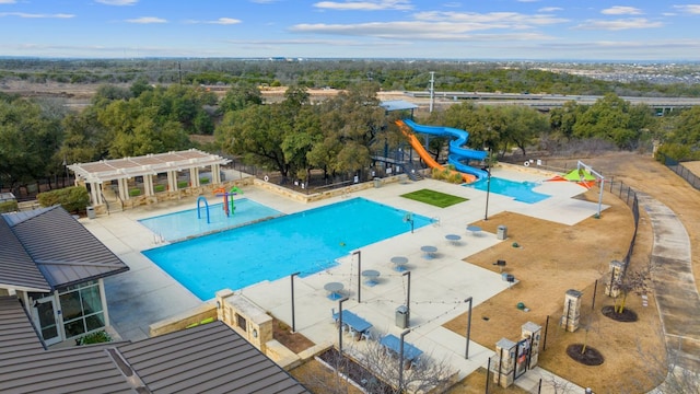 community pool featuring a pergola, a water slide, and a patio area