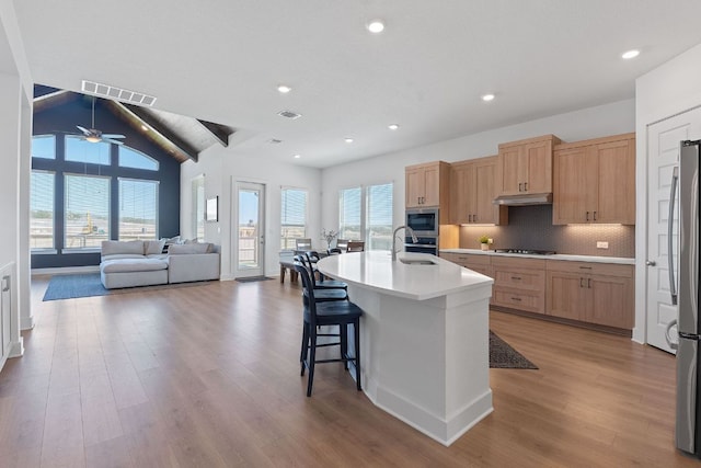 kitchen featuring visible vents, light brown cabinets, stainless steel appliances, and a sink