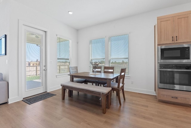 dining area featuring baseboards, light wood-style floors, and recessed lighting