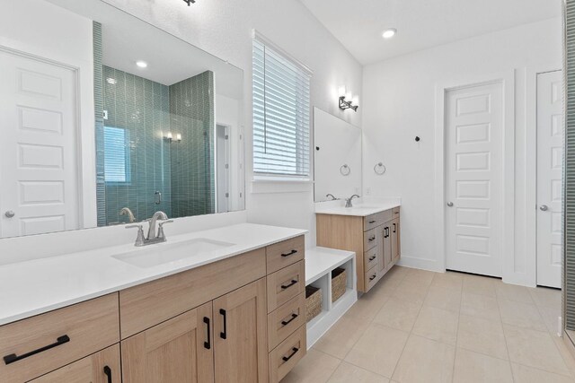 bathroom with two vanities, tile patterned flooring, a stall shower, and a sink